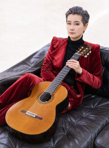 Meng Su posing with a guitar