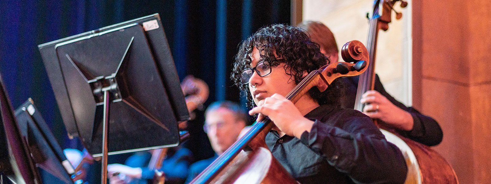 a girl playing the cello as part of a group